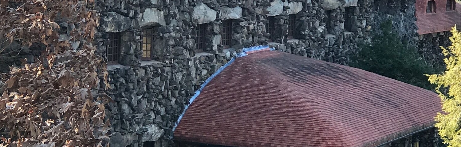 Um edifício de pedra com telhado vermelho e várias janelas.