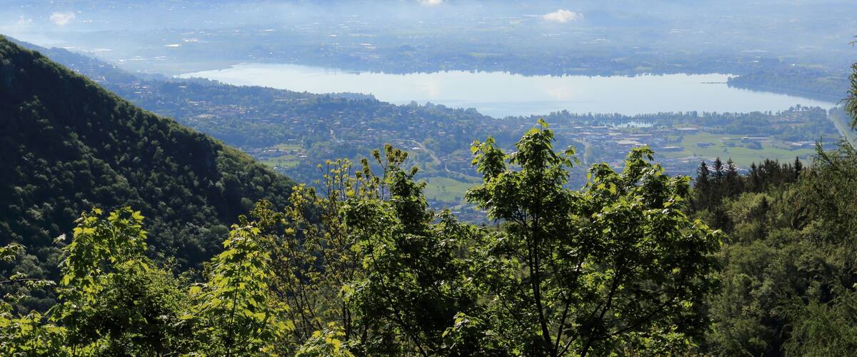 A mountainous landscape with a lake and forested hills.