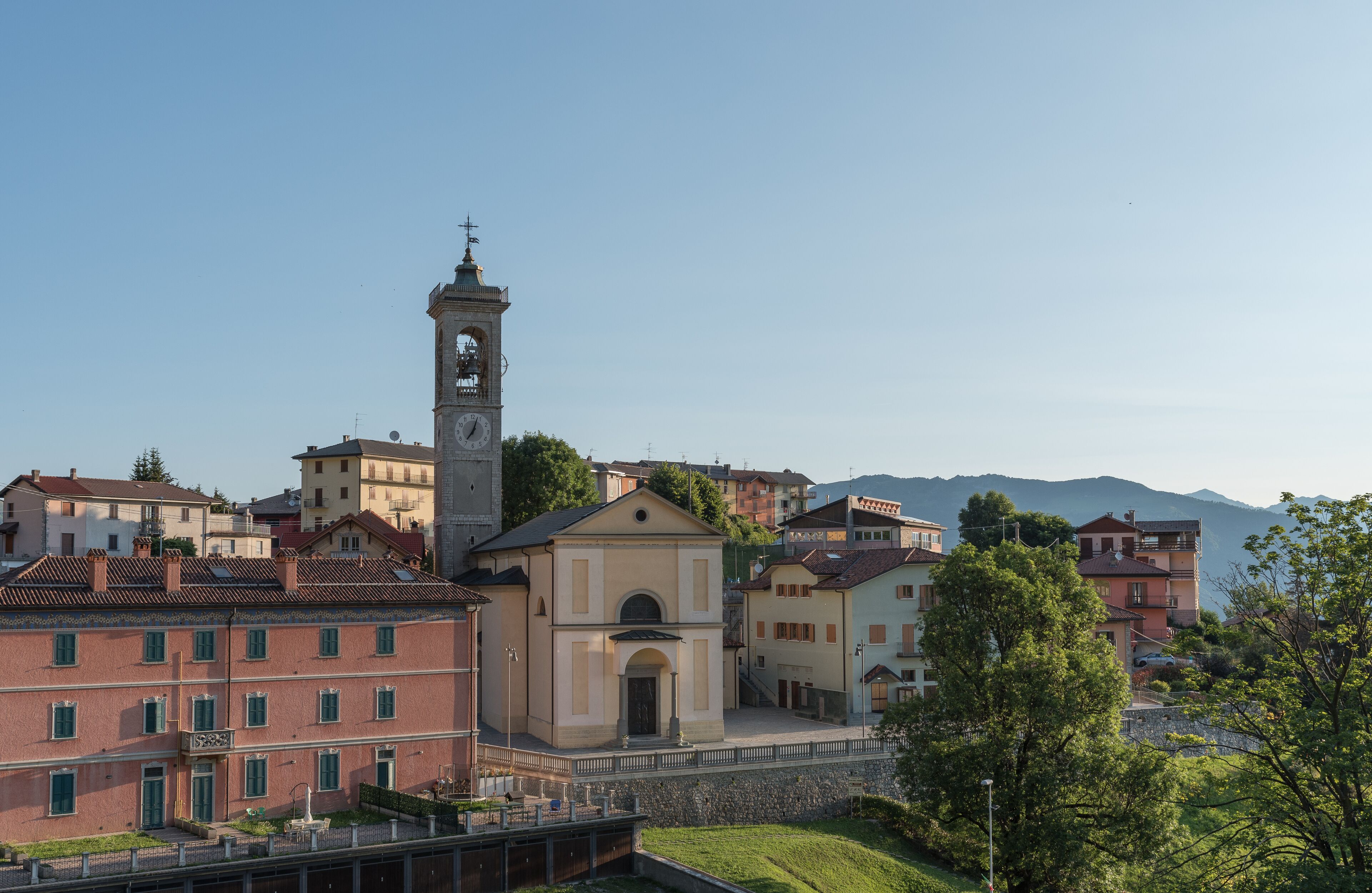 A town with a prominent clock tower, historic buildings, and a river.