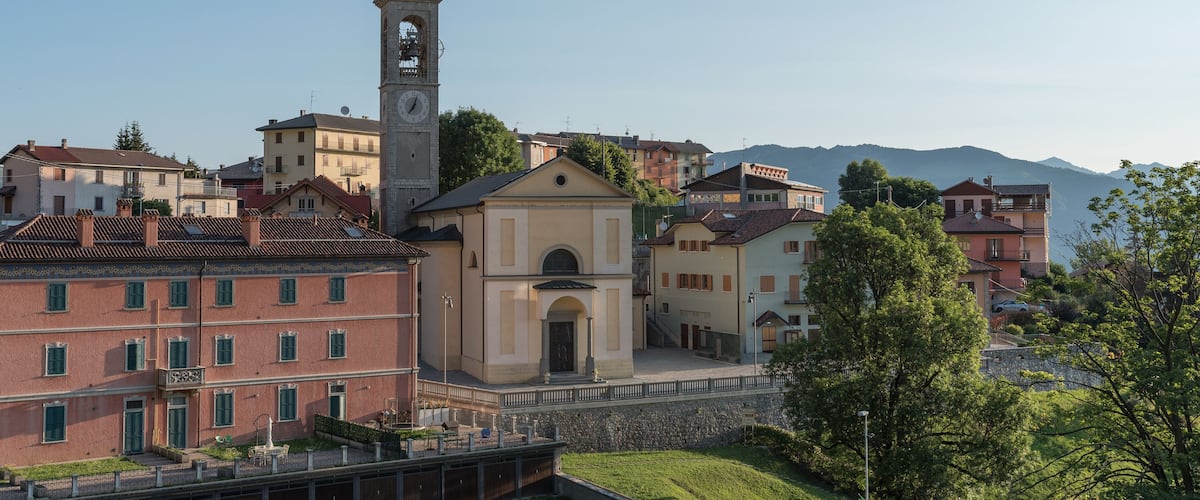A town with a prominent clock tower, historic buildings, and a river.