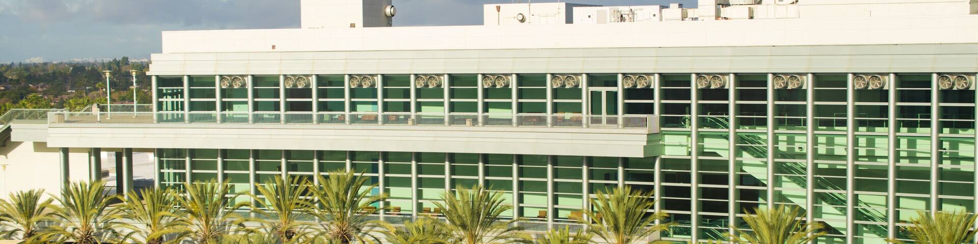 Modern architecture of convention center in California surrounded by palm trees.