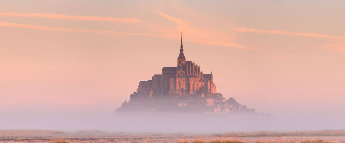 A historic castle surrounded by fog.