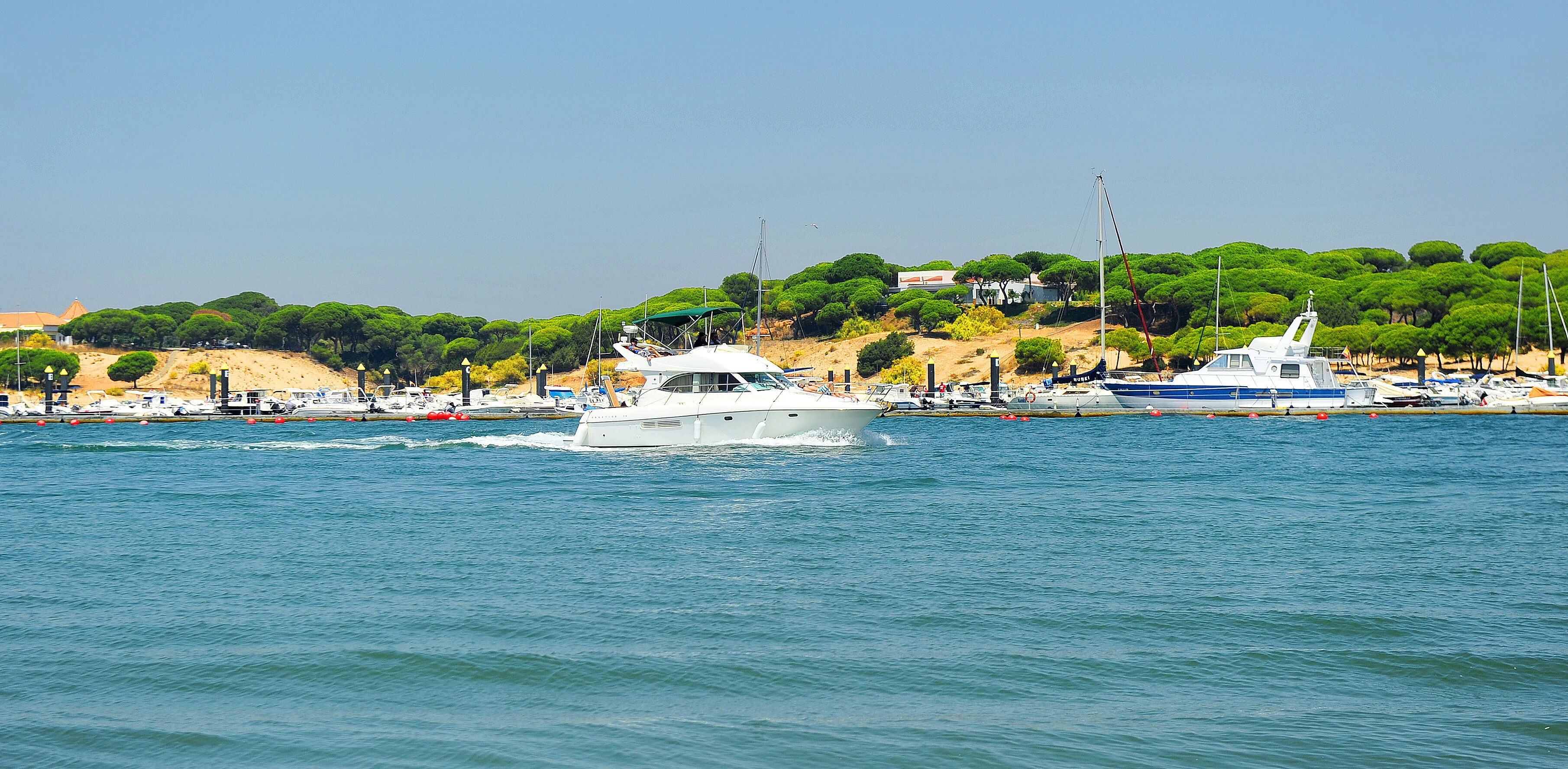 A yacht sails down the River Stones (Rio Piedras) in El Rompido, beaches of Huelva, Andalusia, Spain