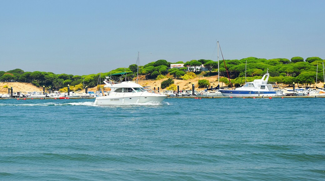 A yacht sails down the River Stones (Rio Piedras) in El Rompido, beaches of Huelva, Andalusia, Spain