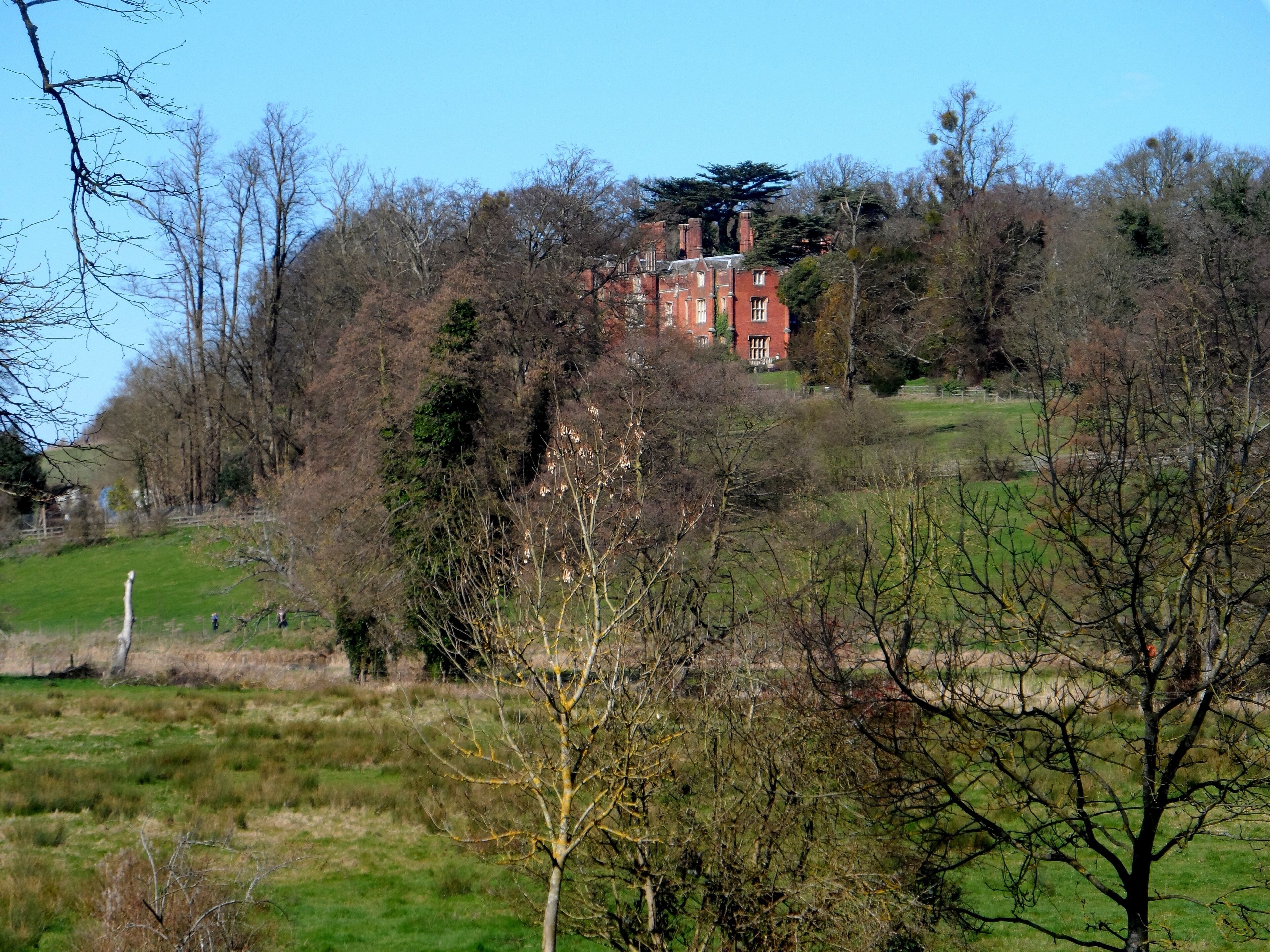 A red brick building surrounded by trees and grass.