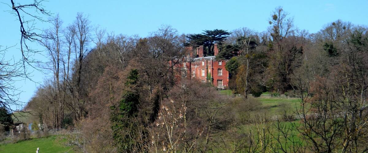 A red brick building surrounded by trees and grass.