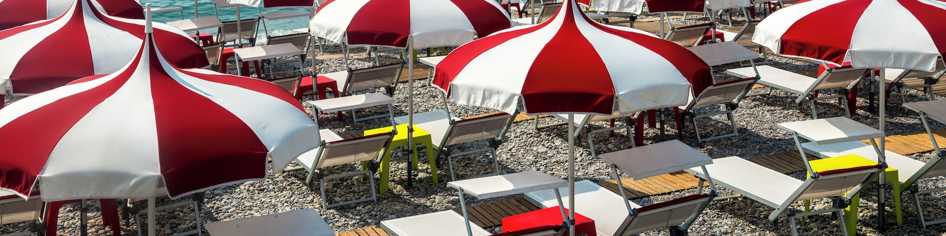 Cagnes-sur-Mer (Alpes-Maritimes, Provence-Alpes-Cote d'Azur, France), red and white umbrellas on the beach