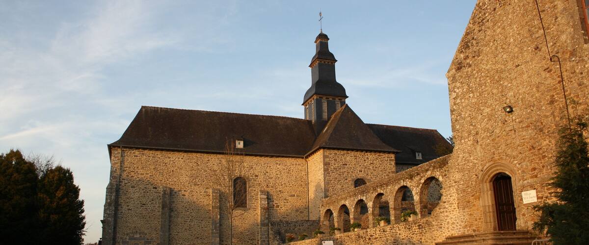 A historic stone building with a prominent tower and arched windows.