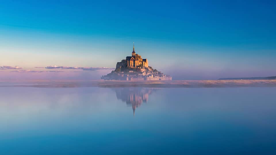 Breathtaking sunrise at the famous Le Mont Saint-Michel tidal island , Normandy, France
