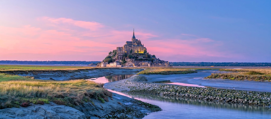 A castle on a hill overlooking a river.