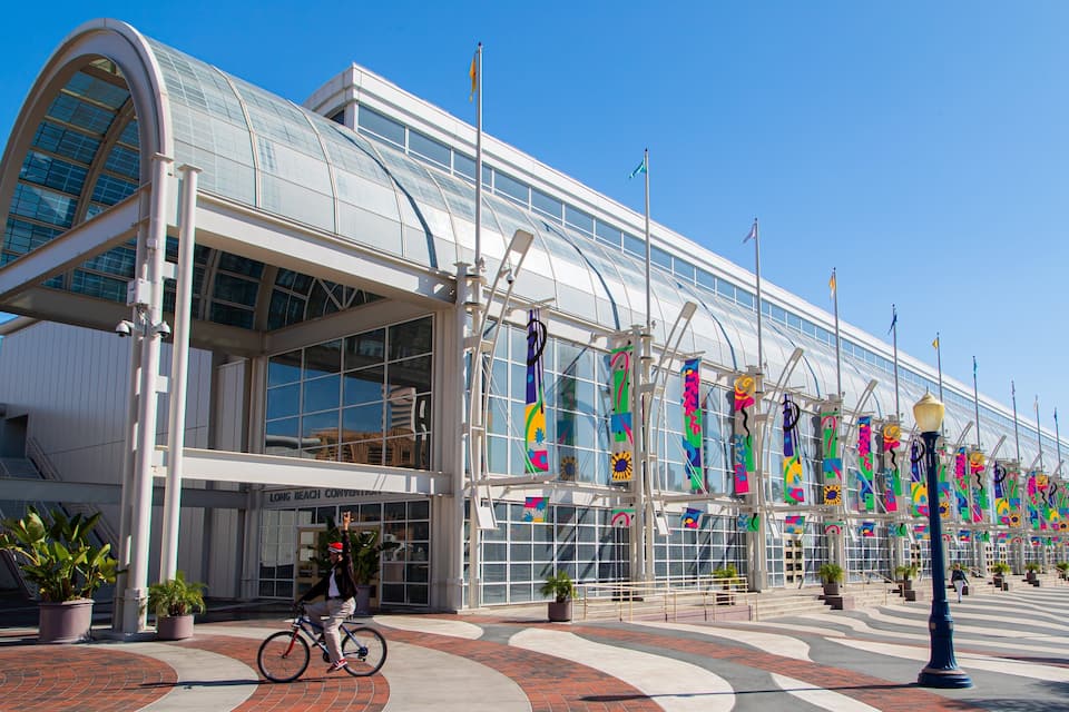A modern building with large glass windows and colorful flags.