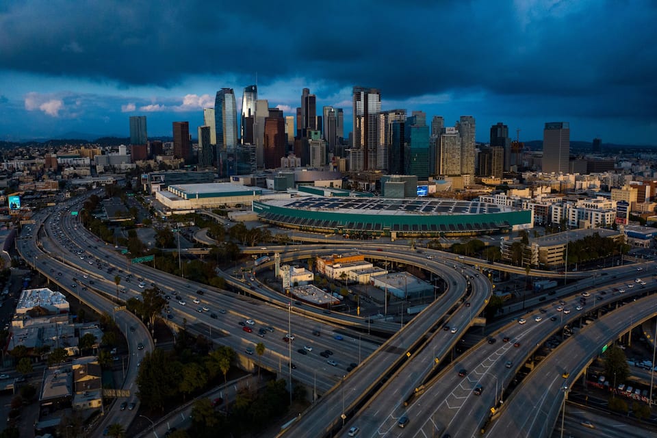 Un horizonte urbano con un estadio destacado y múltiples autopistas.