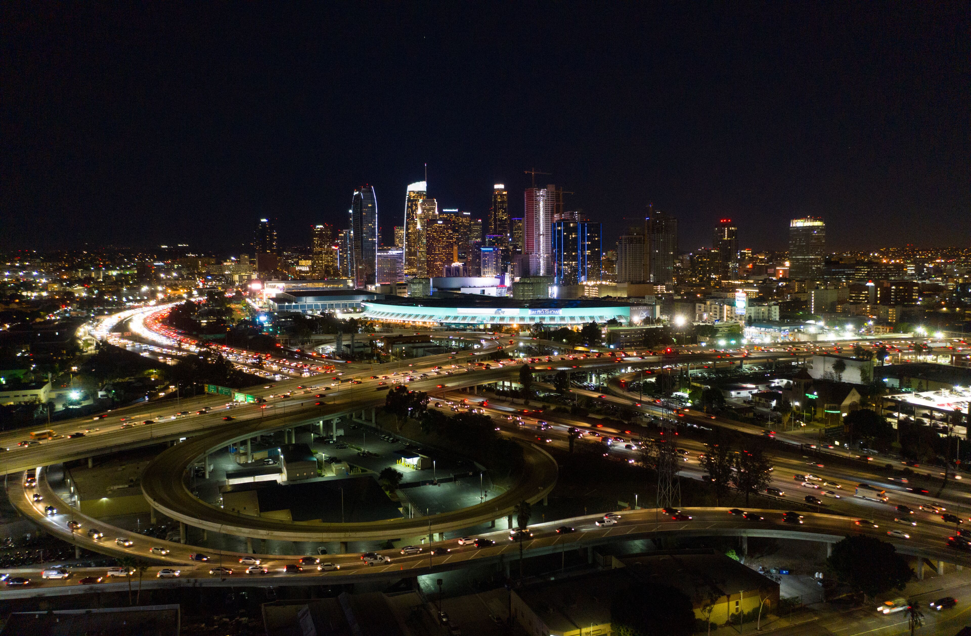 Urban aerial view of the downtown Los Angeles convention center, city skyline and freeway traffic at night