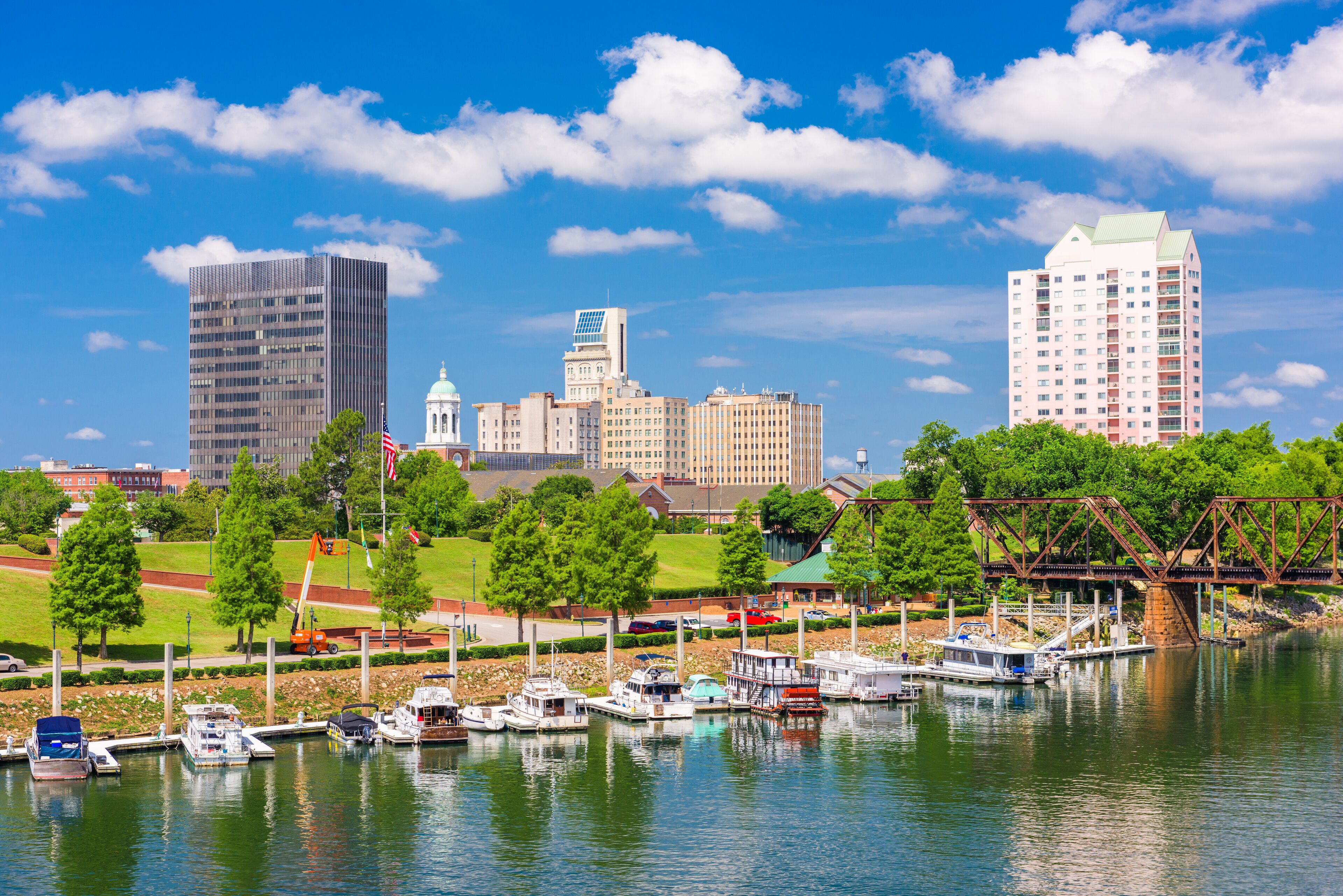 A marina with boats, a bridge, and a city skyline in the background.