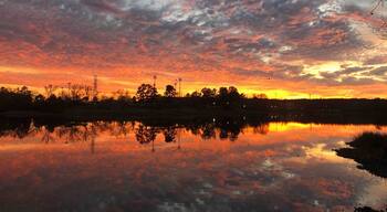 Beautiful sunset over the lake . Many people fishing nearby.