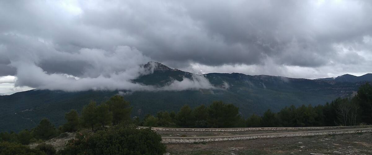A mountain range with clouds partially covering the peaks.
