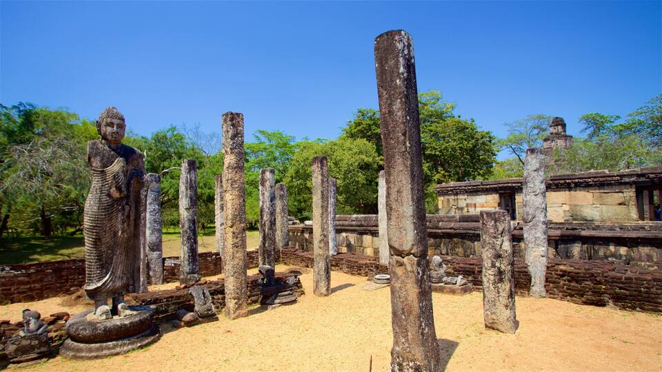 Ancient stone columns and a Buddha statue in a historical site.