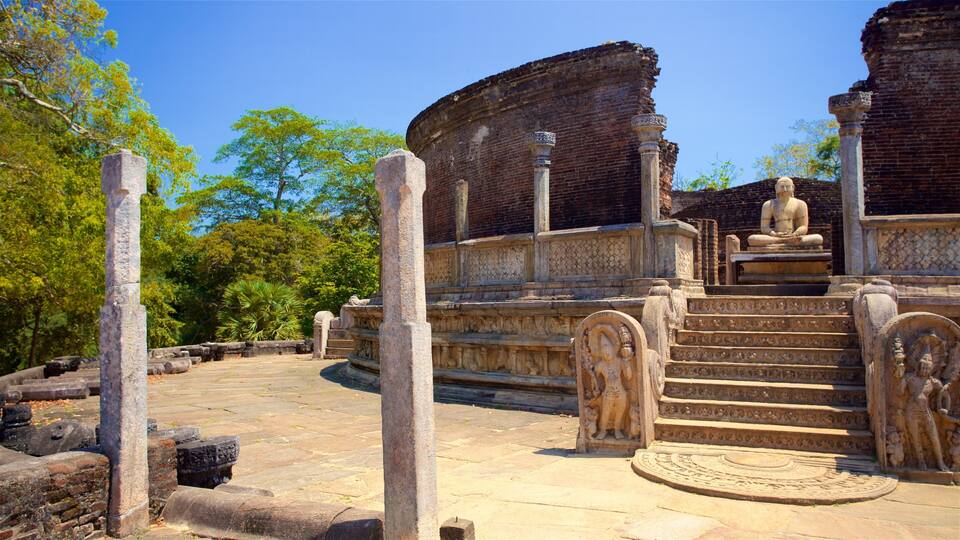 Ancient stone ruins with a seated Buddha statue, intricate carvings, and a circular stone platform.