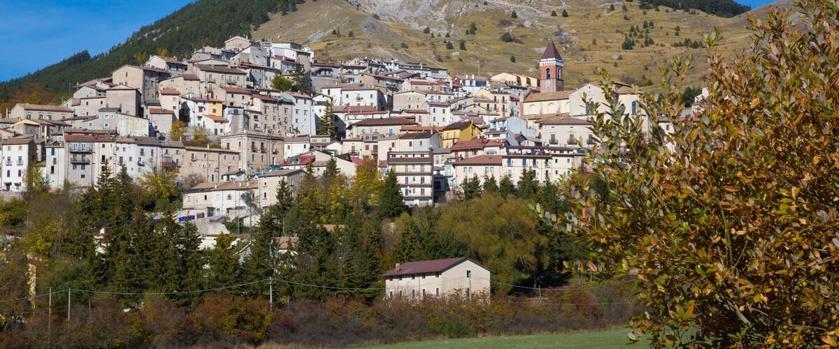 A town nestled in a valley with a prominent hill in the background.
