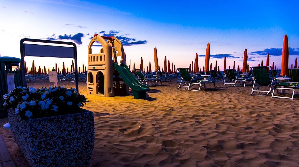 Slide for children on the beach with sunbeds in the background at sunrise time. Jesolo beach, Italy.