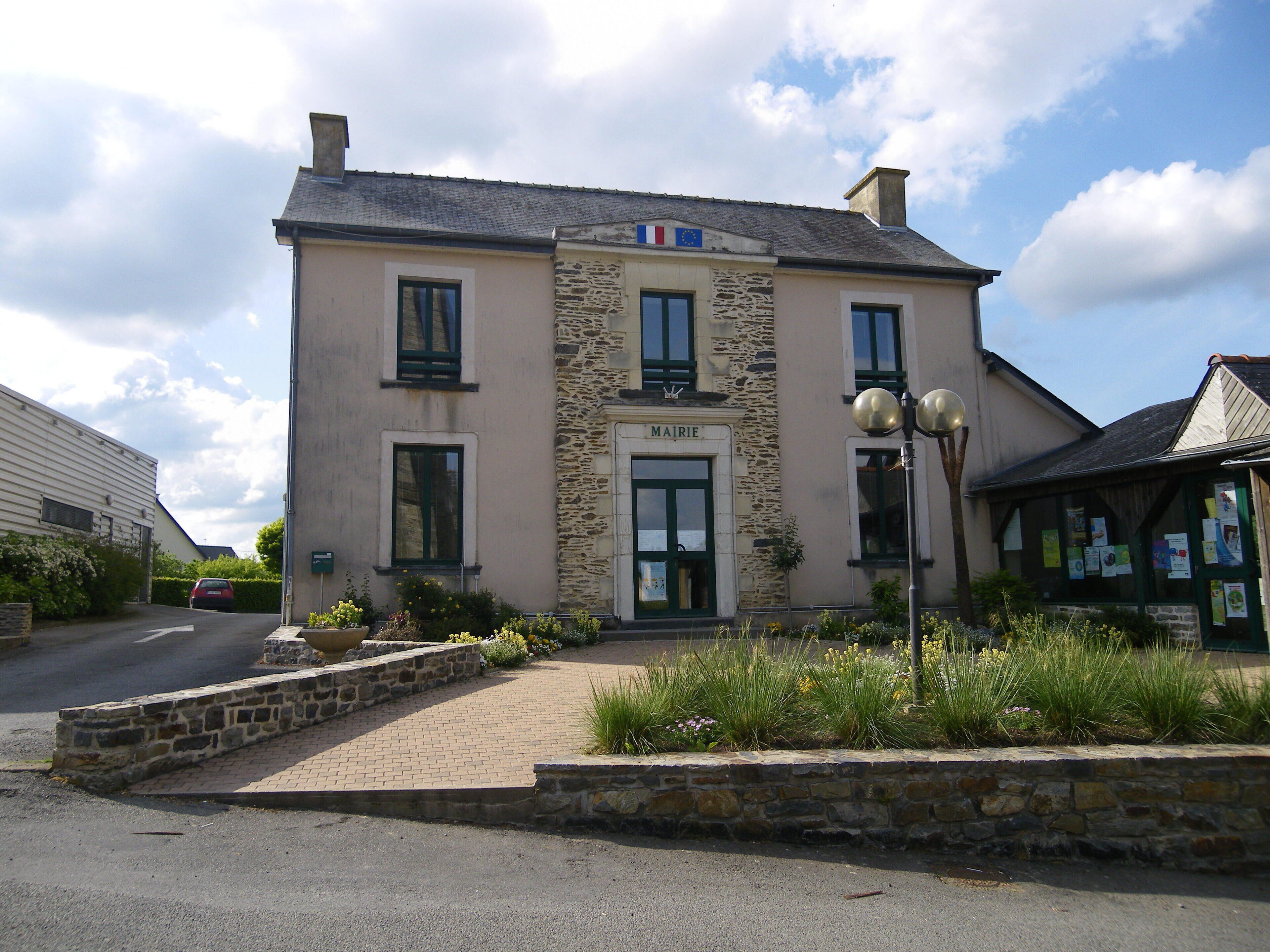 A building with a stone facade, a sign reading "MAIRIE," and a French flag.