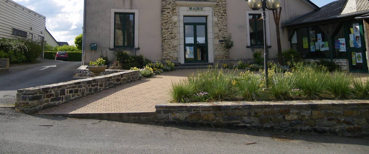 A building with a stone facade, a sign reading "MAIRIE," and a French flag.