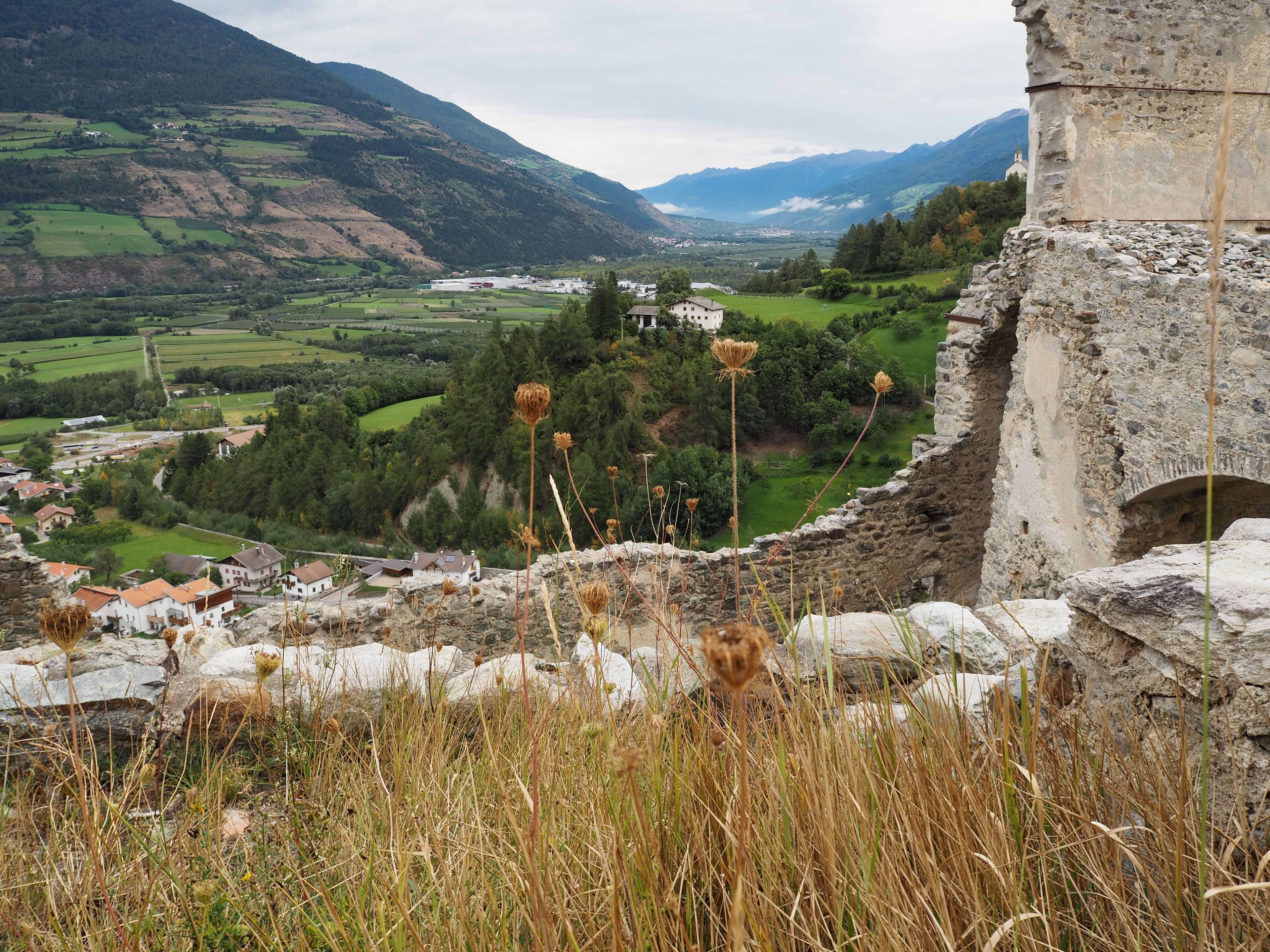A mountainous landscape with a village, stone ruins, and a church.