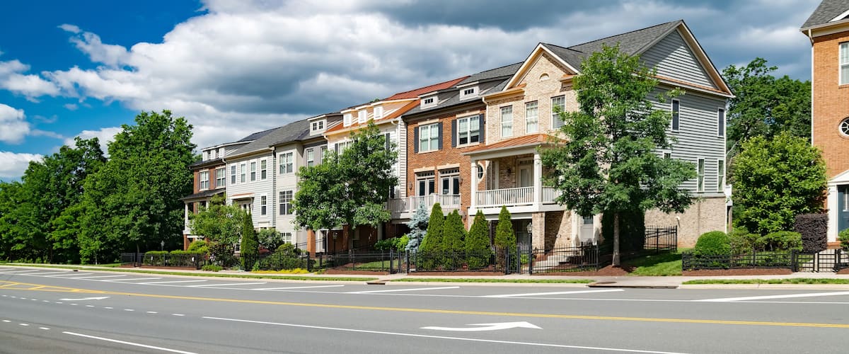 Modern apartment building with roadside parking. Urban development, landscaping.
