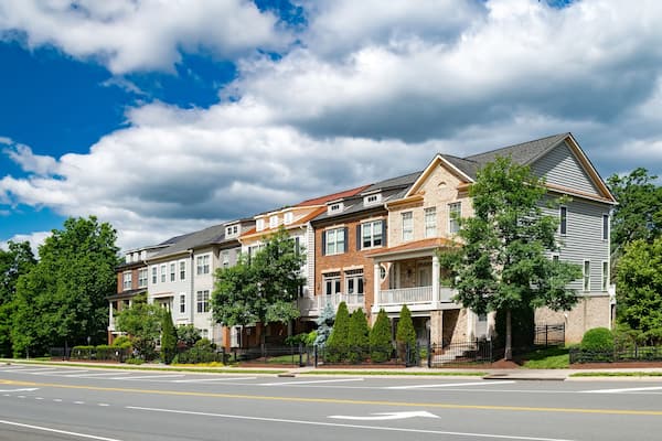 Modern apartment building with roadside parking. Urban development, landscaping.