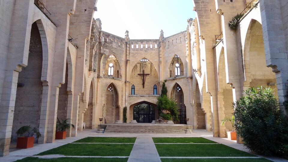 A historic building with arched walkways and a central courtyard.