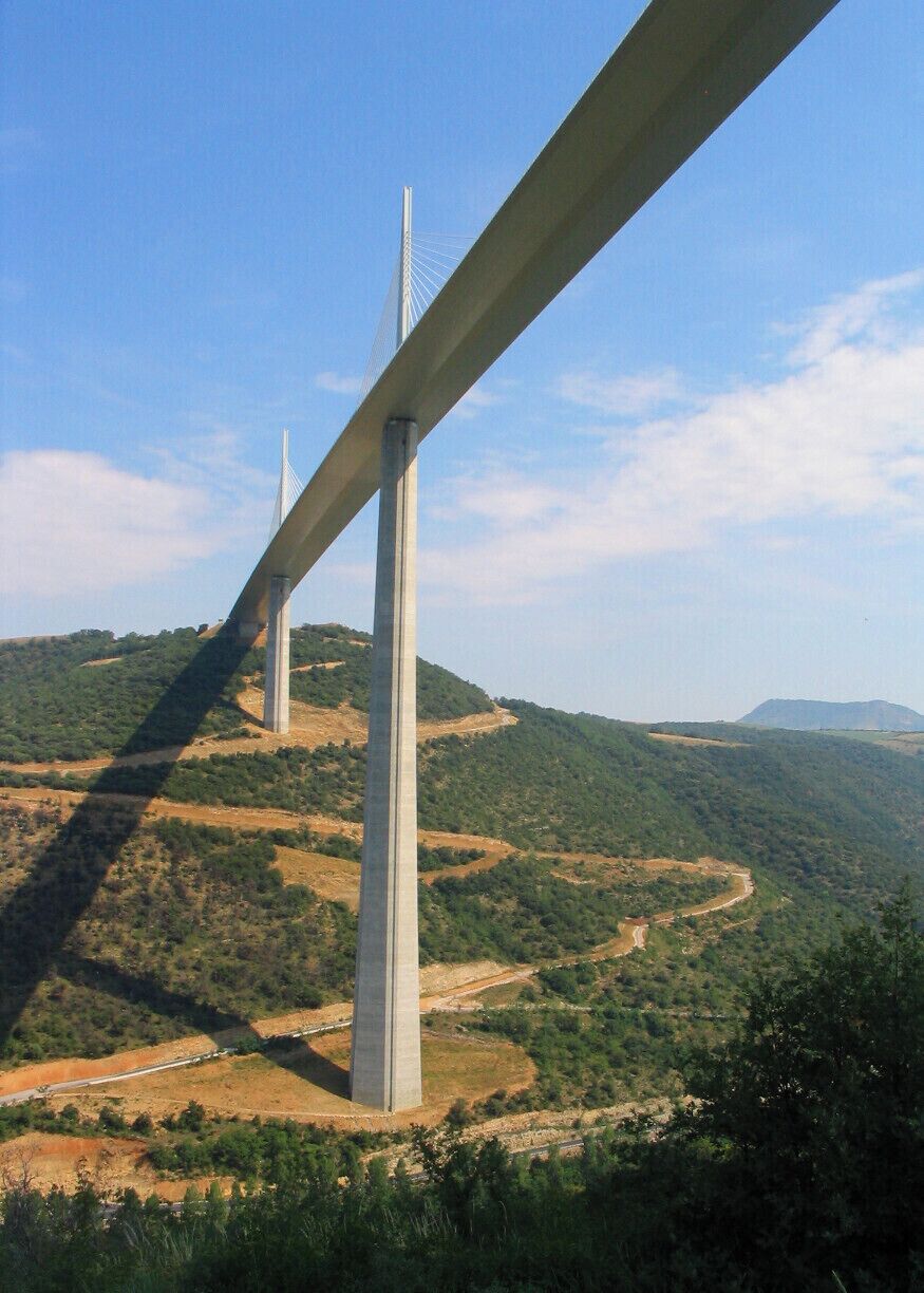 Un puente extenso que cruza un valle con colinas al fondo.