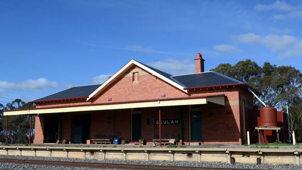 A brick building with a sign reading 'BEULAH' and a water tank nearby.