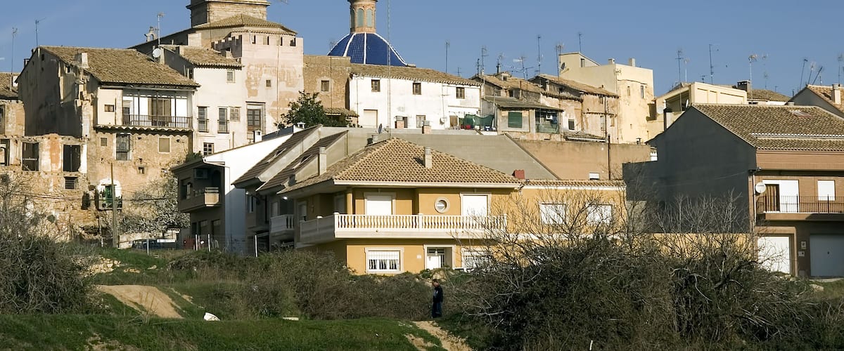 A historic town with a prominent church featuring a bell tower and a blue dome.