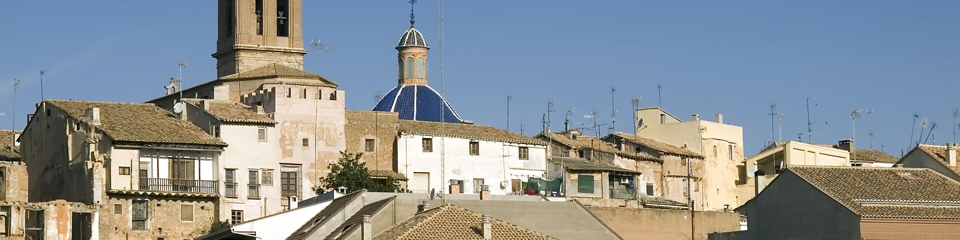 A historic town with a prominent church featuring a bell tower and a blue dome.