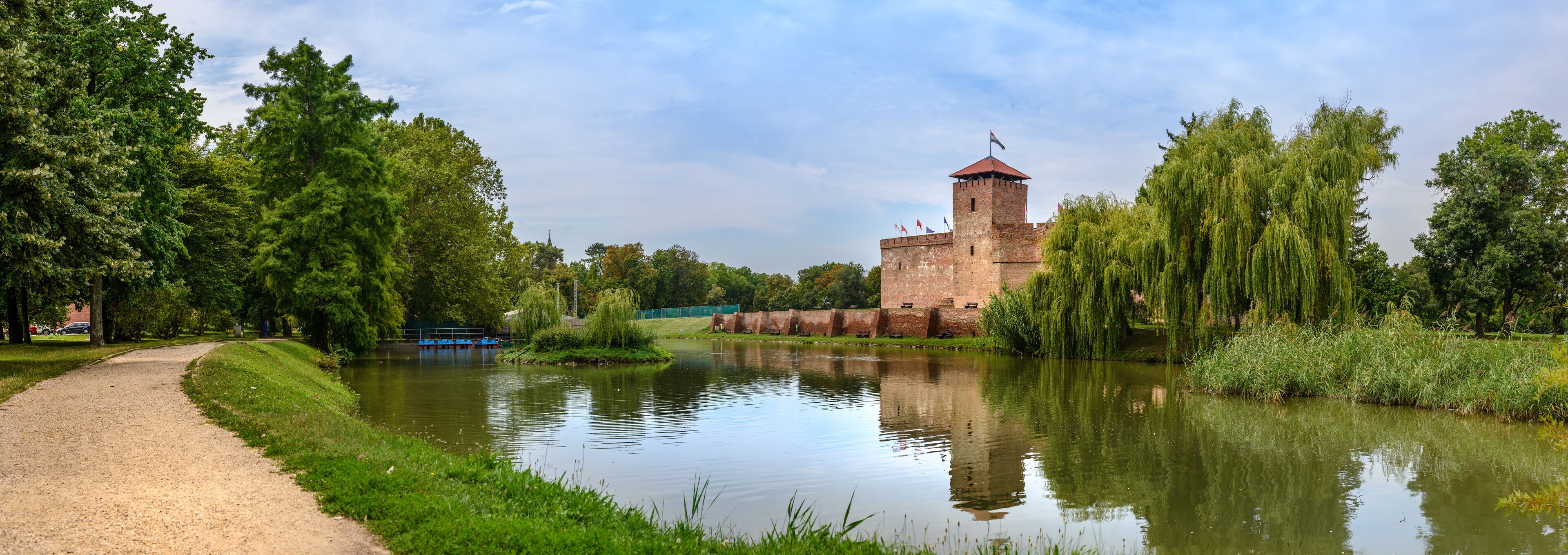 The only remaining brick-built medieval fortress. In front of the castle is a boating lake and a huge willow tree in summer. Big size panorama view, Hungary, Gyula