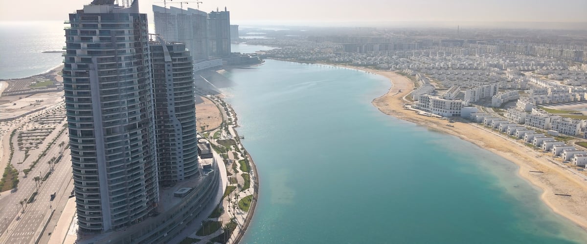 Un paysage urbain côtier avec de hauts immeubles et une baie en forme de courbe.