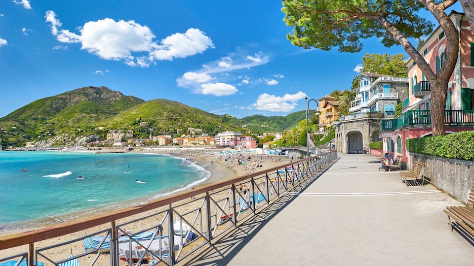 A coastal town with a beach, a promenade, and historic buildings.