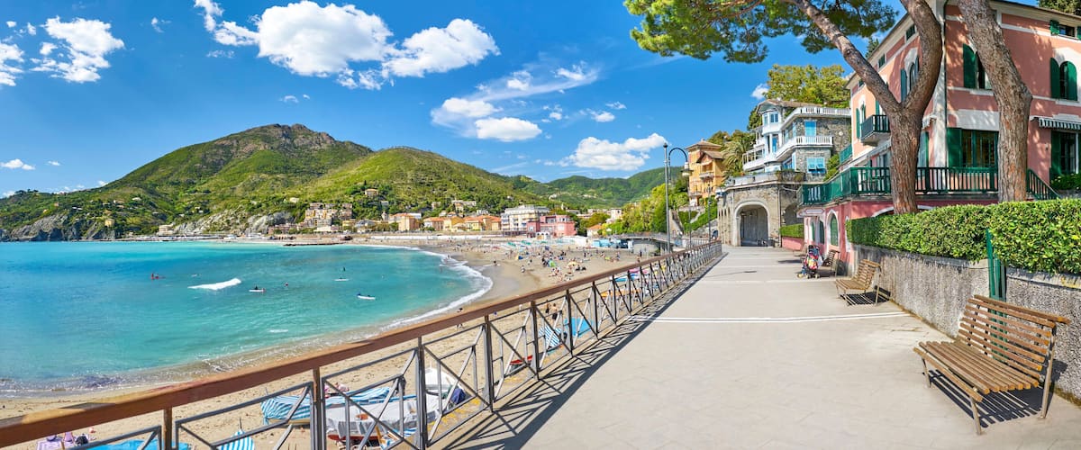 A coastal town with a beach, a promenade, and historic buildings.