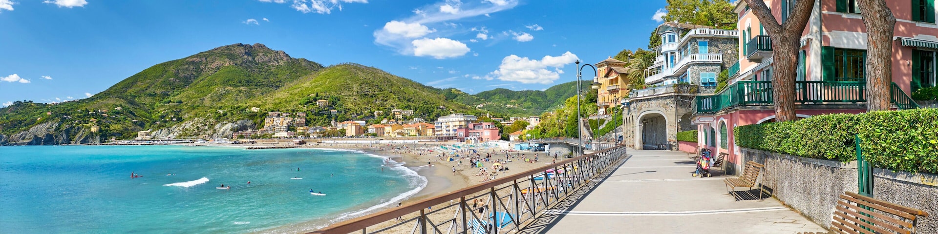 A coastal town with a beach, a promenade, and historic buildings.