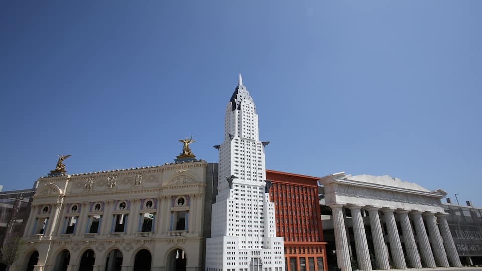 A grand building with a tall tower, classical columns, and statues.