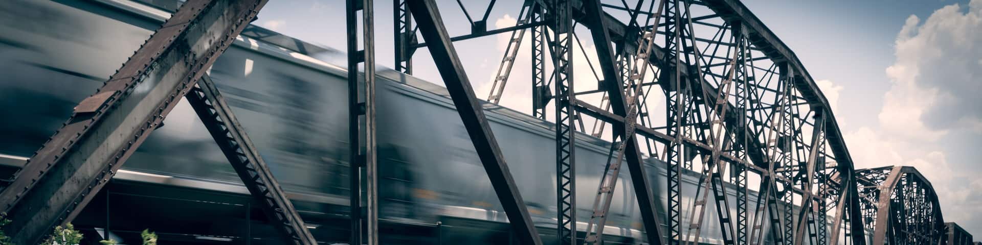 Old rusty truss bridge with moving freight train over the Red River on the border of Texas and Oklahoma