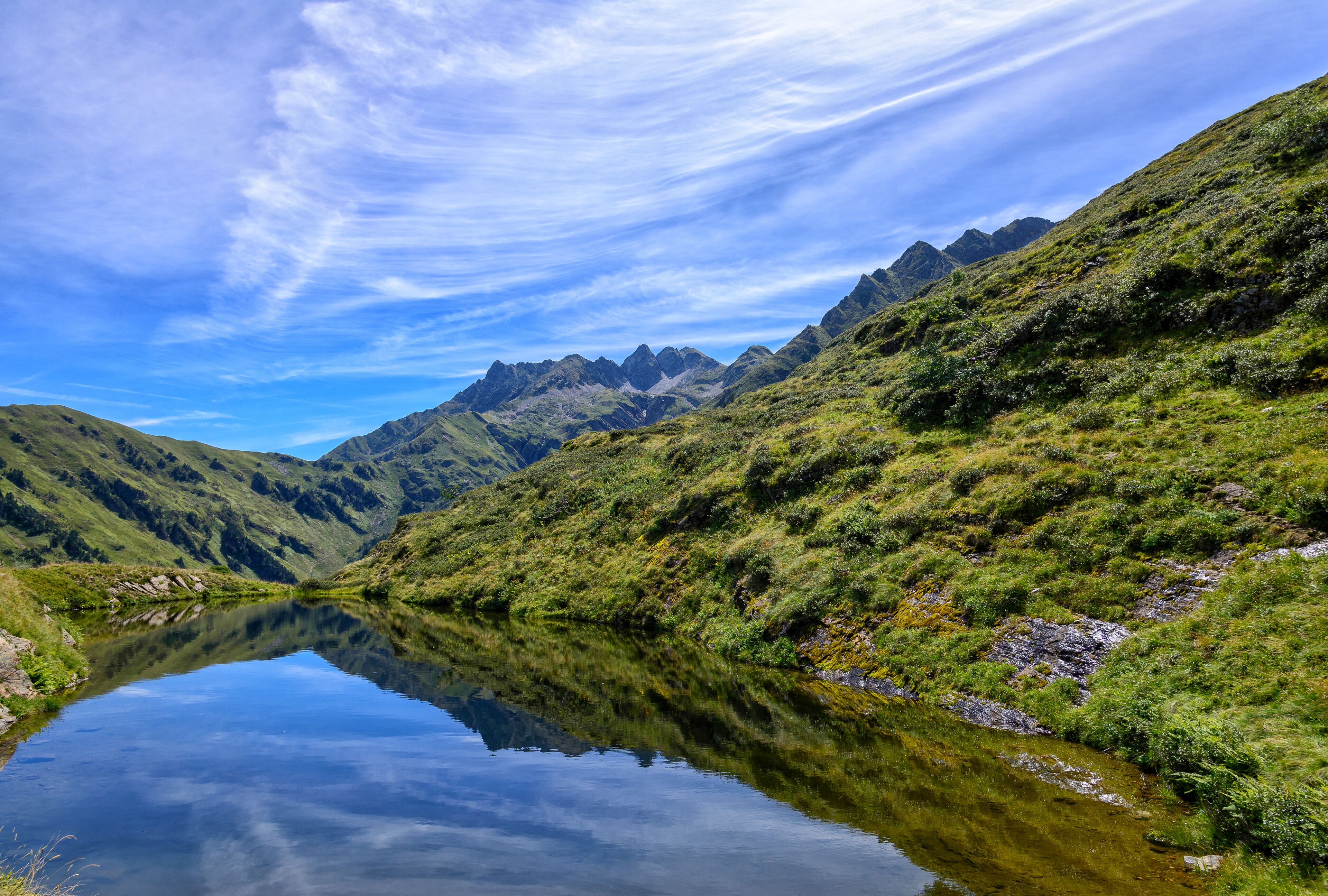 A mountain landscape with a clear lake reflecting the sky.