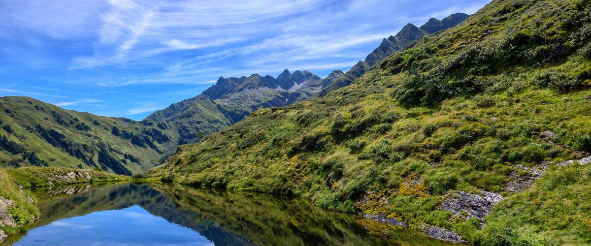 A mountain landscape with a clear lake reflecting the sky.