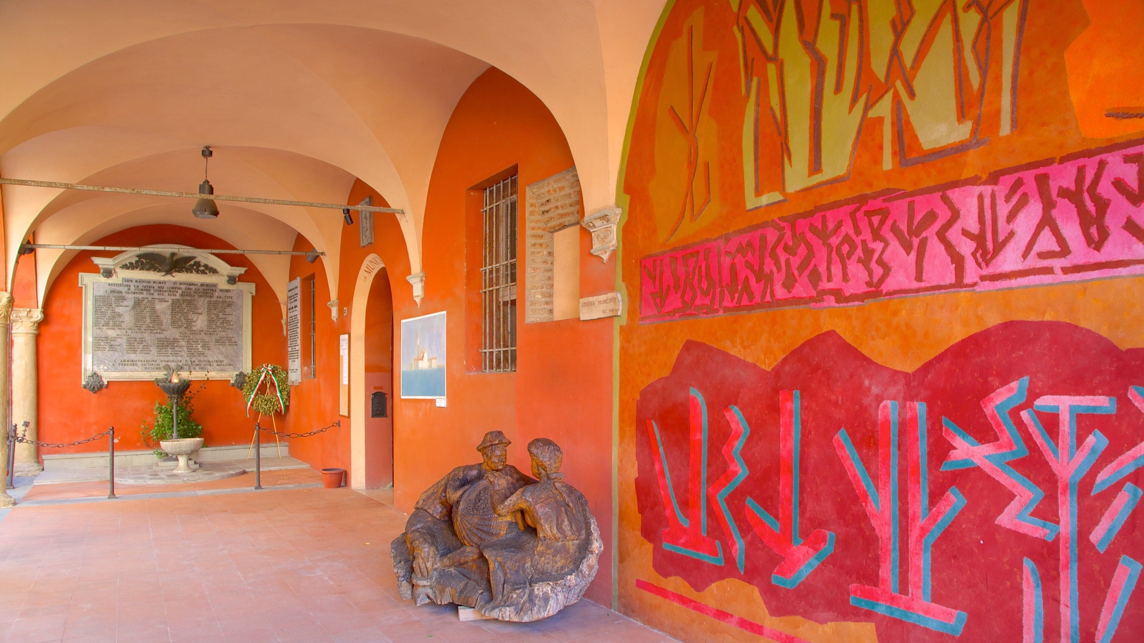 An interior corridor with arched ceilings, a statue, and colorful graffiti.