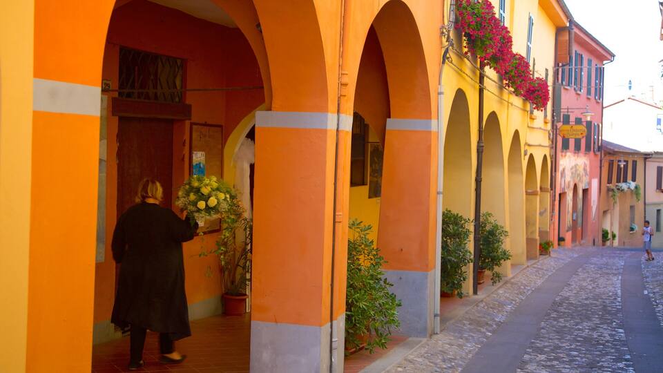 A street with orange buildings, a person holding a bouquet of flowers, and a sign for Osteria.