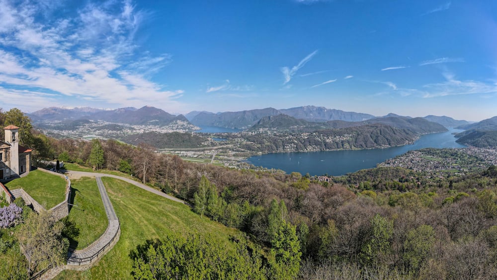 Un paysage montagneux avec un lac, une église et une ville.