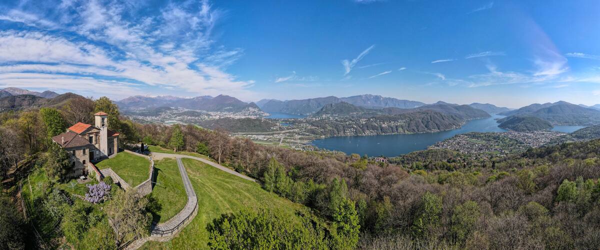 A mountainous landscape with a lake, a church, and a town.