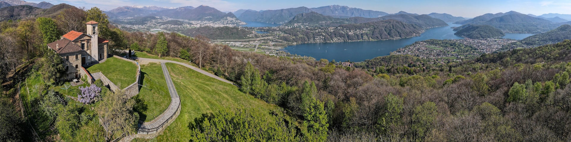 A mountainous landscape with a lake, a church, and a town.