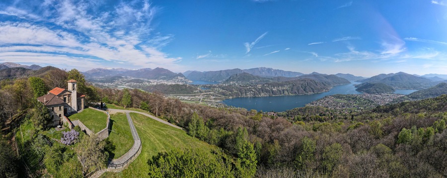 Un paisaje montañoso con un lago, una iglesia y un pueblo.