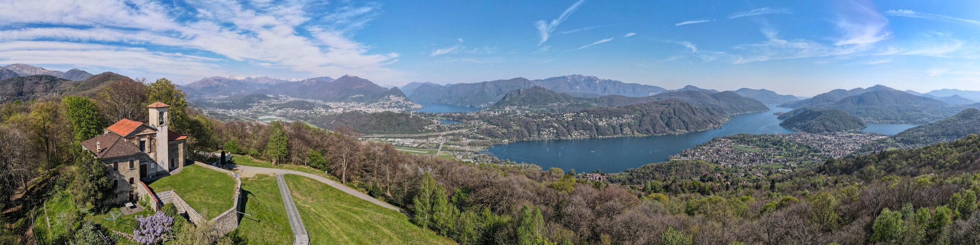 Un paisaje montañoso con un lago, una iglesia y un pueblo.